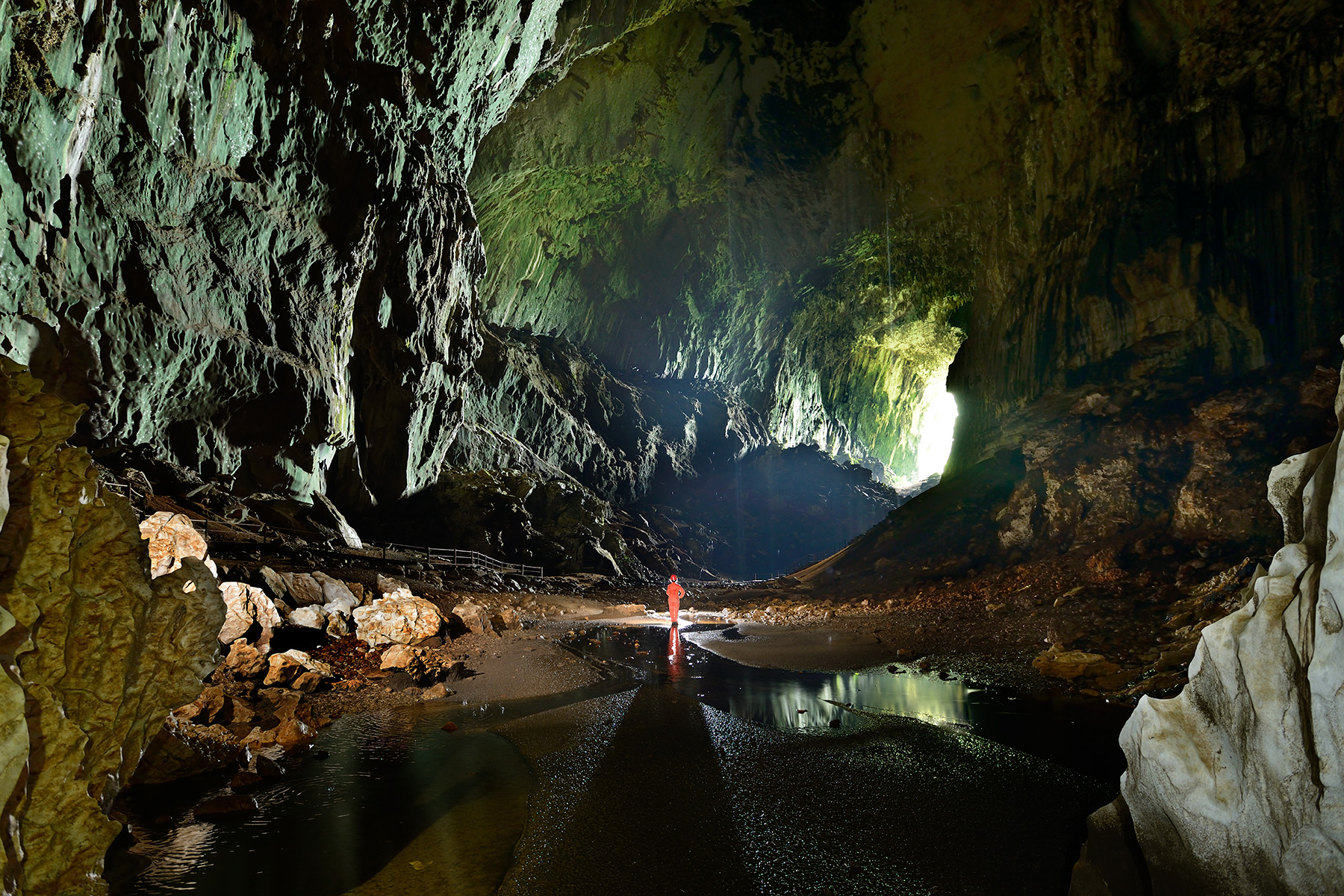 Deer Cave (Gunung Mulu National Park, Bornéo, Malaisie) - Rivière dans galerie d'entrée. Porche d'entrée en fond.